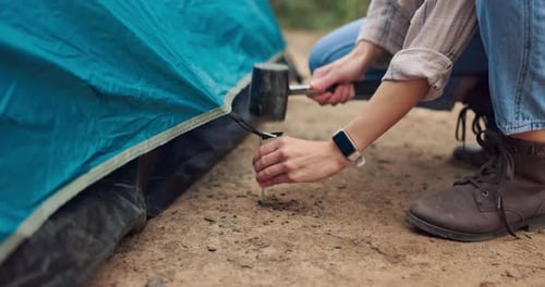 People, campsite and hammer with tent outdoors, nature and survival or adventure with shelter setup