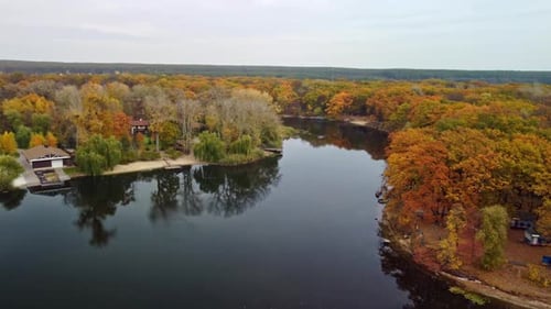 Aerial arc view on river and autumn colorful trees