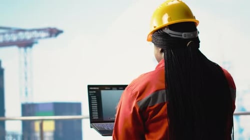 Offshore Rig Worker on Oil Platform Deck Monitoring Operations with Laptop