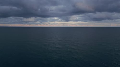 Uma visão panorâmica de um horizonte marinho escuro e um céu dramático antes de uma tempestade à noite