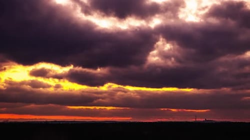 Coucher de soleil Théâtral à travers les cumulus dans un ciel orange au-dessus de l'horizon Timelapse