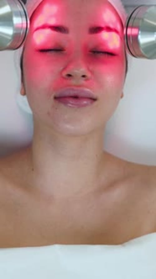 Woman Experiences LED Red Light Facial Treatment in Skincare Clinic for Antiaging Rejuvenating