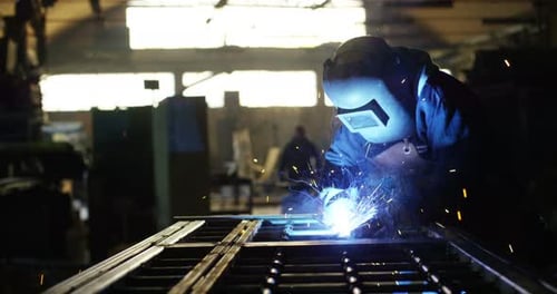 Welder Working with Bright Sparks in Factory