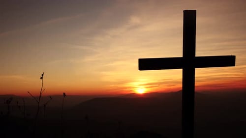 Silhouette of the Cross Against the Canvas of the Sunset Sky