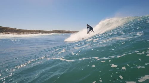 Male surfer riding the perfect turquoise blue ocean wave on a sunny day