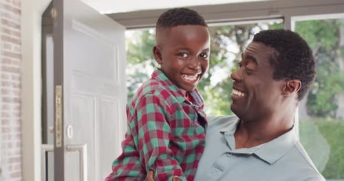 Cheerful Father Holding Young Son Inside Home
