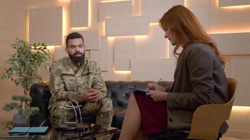 Man in uniform talking with woman in office