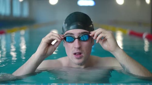Front View Portrait of Caucasian Sportsman Putting on Goggles Diving Underwater in Slow Motion