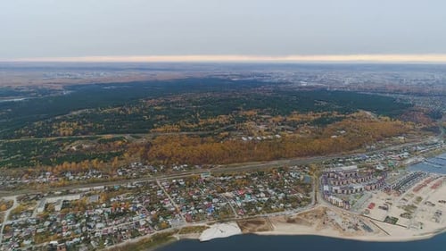 Luftpanorama: Stadt am Seeufer gegen Kiefern-Birkenholz