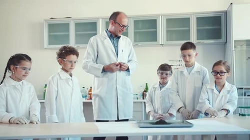 Enthusiastic Children Doing Science Experiment with Teacher