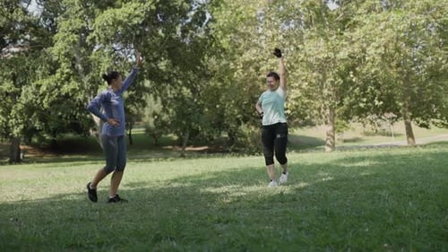 Fitness Instructor Leading Woman in Outdoor Park Workout