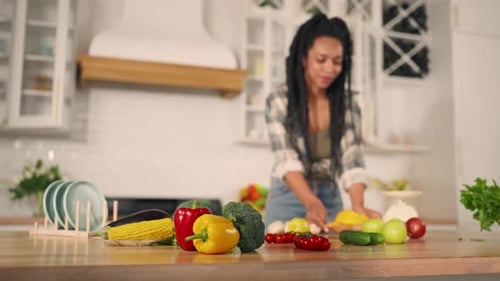 Stylish Woman Chopping Vegetables in Bright Kitchen