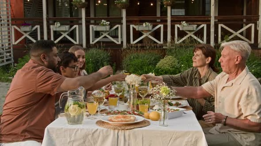 Cover for Happy Family Gathered at Dinner Table at Meal