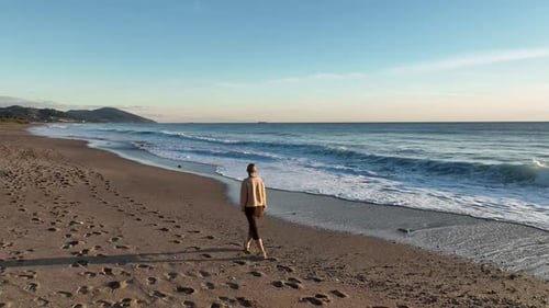 A Beautiful Girl Walks on the Beach of the Mediterranean Sea and Enjoys a Beautiful Sunset