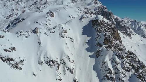 Une immense chaîne de montagnes enneigée avec d'énormes collines rocheuses, des images aériennes en 4k