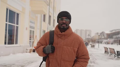 Person Navigates Snowy City Street with Quiet Surroundings Solitary Figure Walks Through Snowcovered