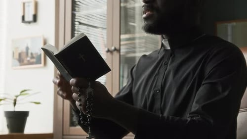 Man Reciting the Bible Holding a Rosary