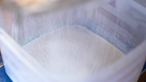 Sifting Fine White Powdered Ingredient Into Container