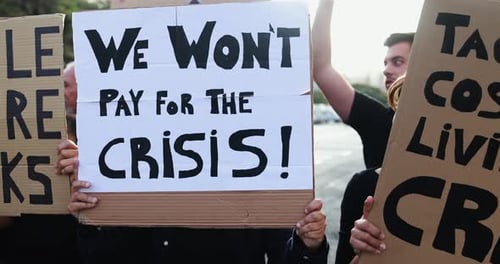 People protesting holding signs outside during the day