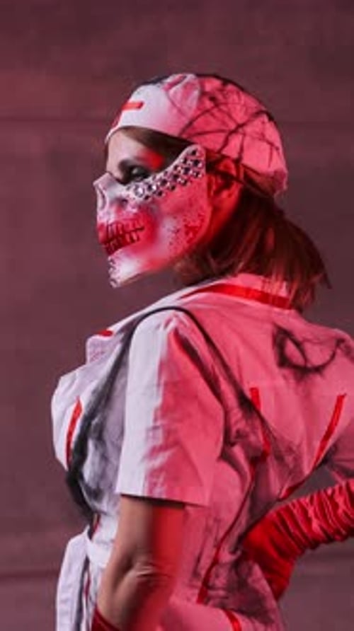 Beautiful sexy girl in scary nurse costume, red gloves and scary mask for Halloween on black backgro