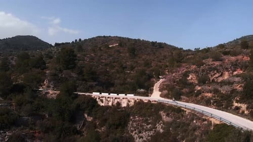 Professional road cyclist riding bicycle in mountains on empty asphalt road