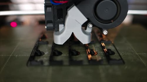 3D-Drucker arbeitet beim Zusammenbau eines schwarzen Kunststoffobjekts im Werk