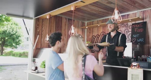 Propietario de un camión de comida que atiende a los clientes