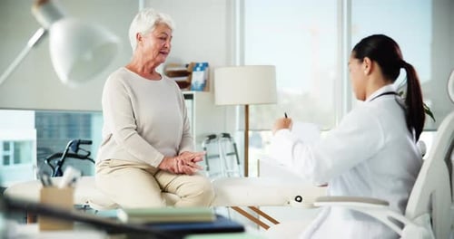 Senior Woman Talking With Doctor in Clinic