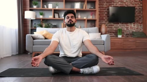 Indian Man Practicing Meditation in Lotus Pose at Home