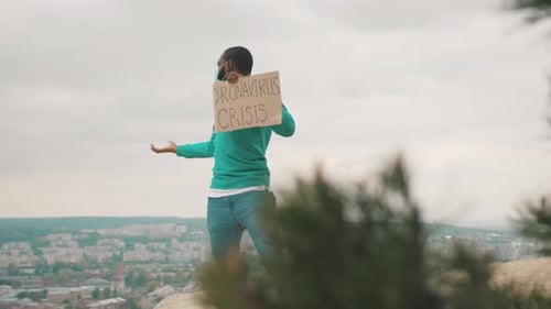 Adult Holding a Sign on a Hilltop