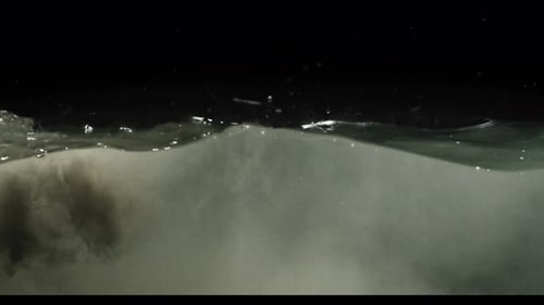 Submerge Collection: Murky waves of water flowing slowly over a black background