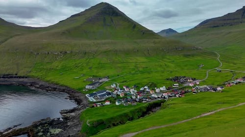 Vue aérienne époustouflante du village de Tjornuvik niché dans les paysages verdoyants des îles Féroé
