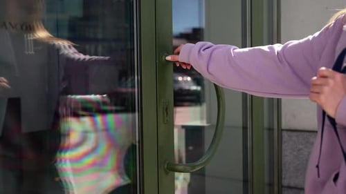 Person Opening a Green Glass Door Hand Reflected in the Glass