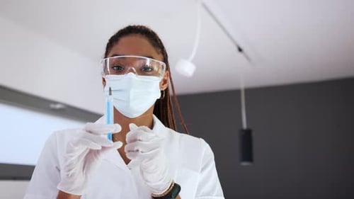 Young Woman Medical Professional Holding Syringe in Hospital