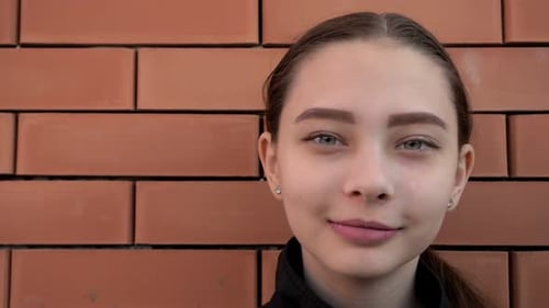 Young Woman Portrait Against Brick Wall