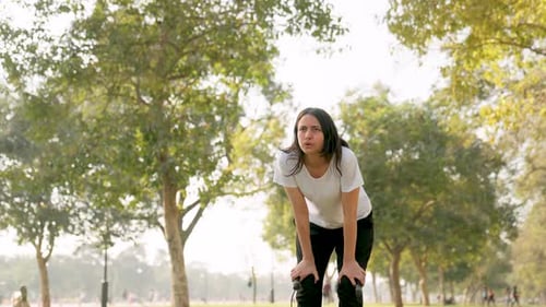 Tired Woman Skipping Rope in Sunny Park