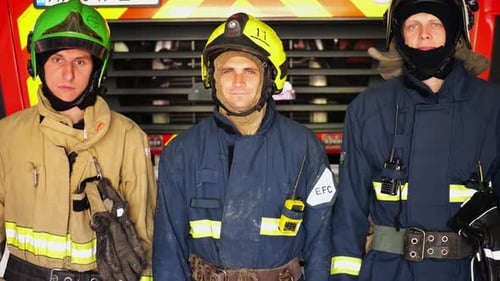 Three Firefighters in Uniform Stand by Firetruck