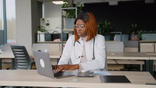 Doctor Reviews X-Ray at Computer in Office