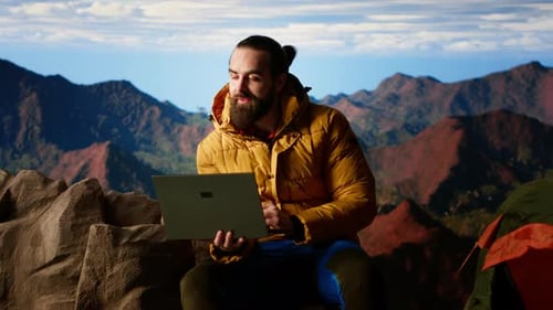 Man Using Laptop in Beautiful Mountain Setting