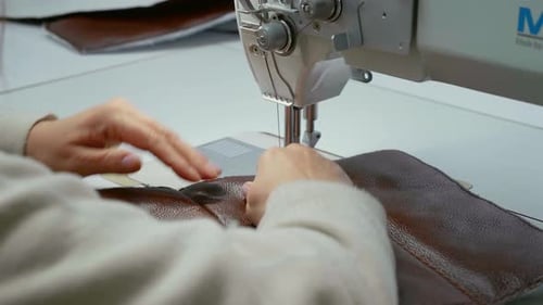 Close-up view of working sewing machine stitching leather.
