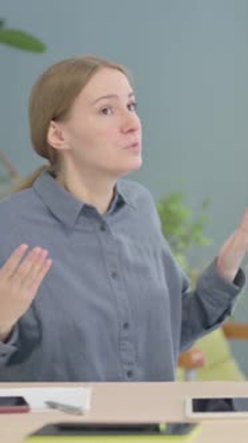 Woman Talking While Sitting at Table Indoors