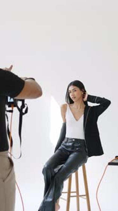 Stylish Woman Posing for Photographer in White Studio