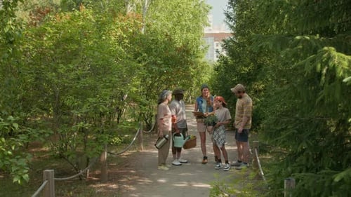 Vielfältige Gruppe von Nachbarn diskutiert über Gartenarbeit im Gemeinschaftspark