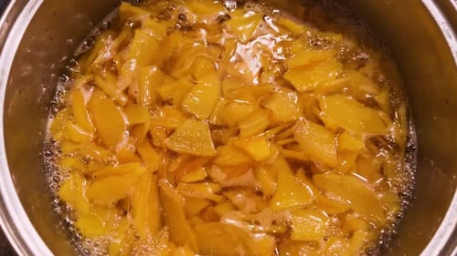Quittenmarmelade kocht in einem großen Topf. Die Marmelade mit einem Silikonspatel umrühren
.