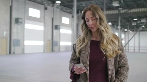 Confident Woman Owner in Empty Warehouse
