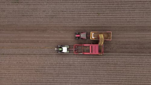 Aerial View of Tractors Harvesting Crops in Field