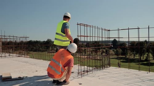 Engineers Inspecting Steel Reinforcement at Construction Site Two Construction Engineers in Safety