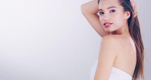 A beautiful young woman playing with her hair in the studio