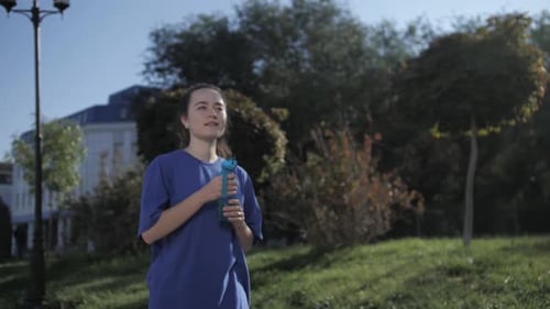 Fitness girl drinking water after workout. Athletic girl Drink water After jog in stadium.