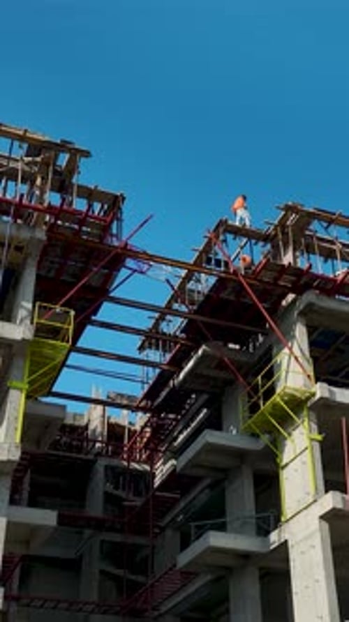 Vertical Aerial View Construction Grid with Workers Operating in Different Sections of Site